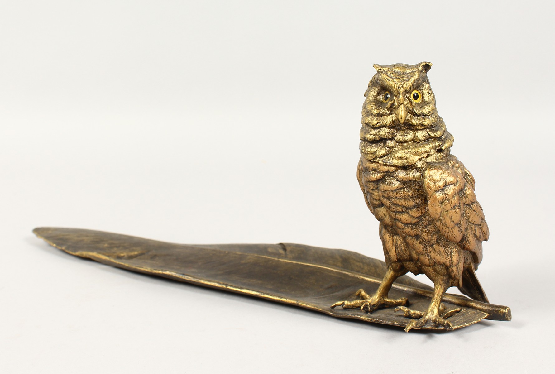 A GOOD BRONZE OWL INKSTAND standing on a feather quill. 13ins long.