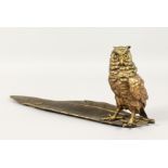 A GOOD BRONZE OWL INKSTAND standing on a feather quill. 13ins long.