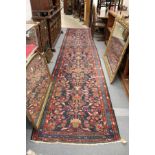 A Persian runner, or hall carpet, dark blue ground with stylized floral decoration.