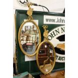 A pair of gilt framed oval mirrors.