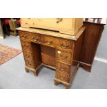 A reproduction mahogany kneehole desk.