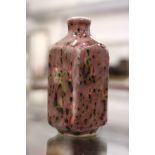 A Chinese peach bloom porcelain snuff bottle.