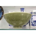 A Chinese celadon bowl with incised decoration.