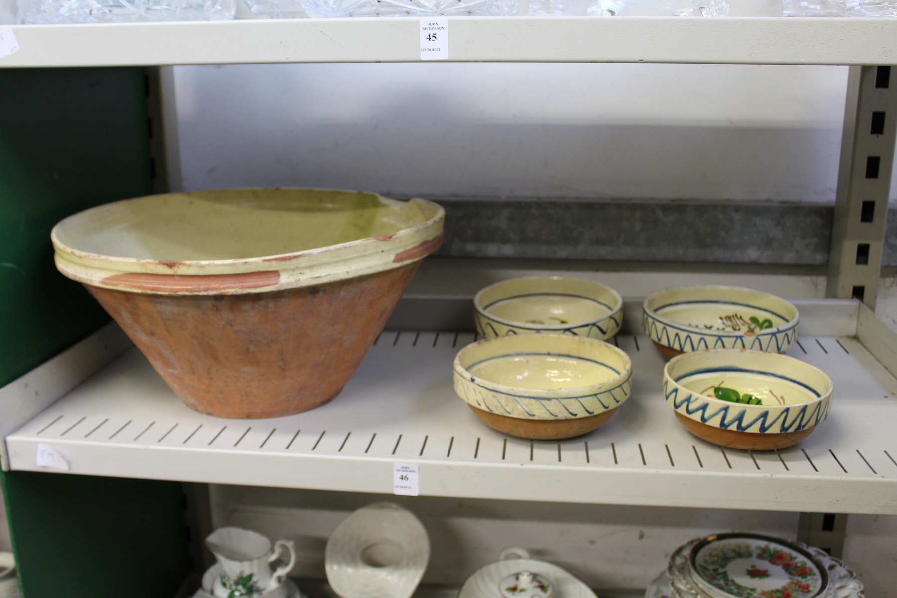 A part glazed terracotta bowl and a set of four hand painted bowls.