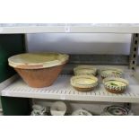 A part glazed terracotta bowl and a set of four hand painted bowls.