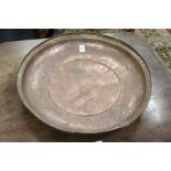 An engraved copper circular bowl.