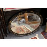 An oval wall mirror with chinoiserie decorated black lacquer frame.