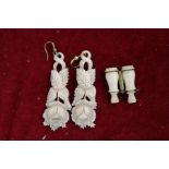 A miniature ivory model of binoculars and a pair of carved bone earrings.