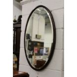 An oval mahogany framed wall mirror.