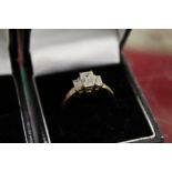 A 9ct gold ring set with three emerald cut stones.