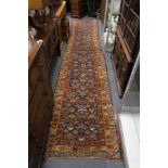 An old Persian runner, blue ground with geometric design.