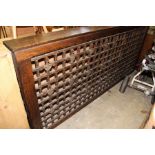 A large lattice work wooden radiator cover.