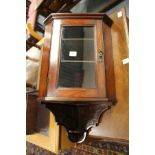 A small mahogany hanging cabinet.