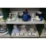 Two shelves of part dinner services and other decorative china.