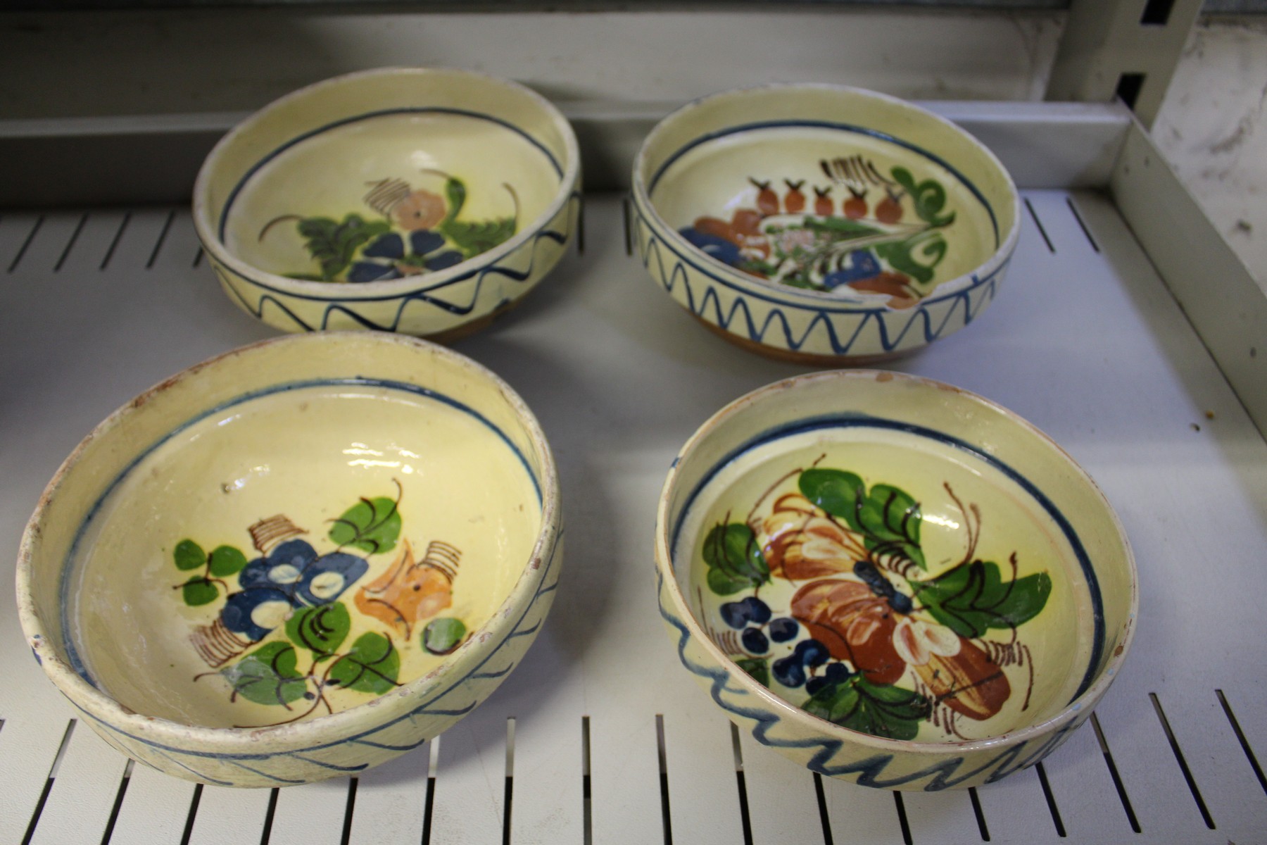 A part glazed terracotta bowl and a set of four hand painted bowls. - Image 2 of 3