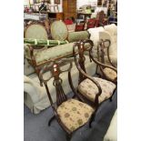 A late Victorian inlaid walnut salon suite comprising a two seater settee, an armchair and a pair of