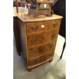 A small yew wood chest of drawers.