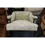 A small Edwardian square shaped upholstered armchair.