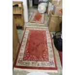 Two small Chinese red ground rugs.