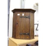 A small oak hanging corner cupboard.