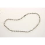 A decorative silver necklace set with pearls.