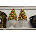 A pair of painted plaster ornaments modelled as vases filled with fruit.