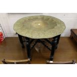 An Islamic brass try table with ebonised folding stand.