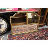 An arch shaped gilt framed mirror.