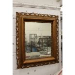 A decoratively framed wall mirror.