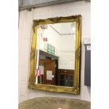 A large gilt framed mirror.