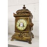 A decorative cast brass mantle clock.