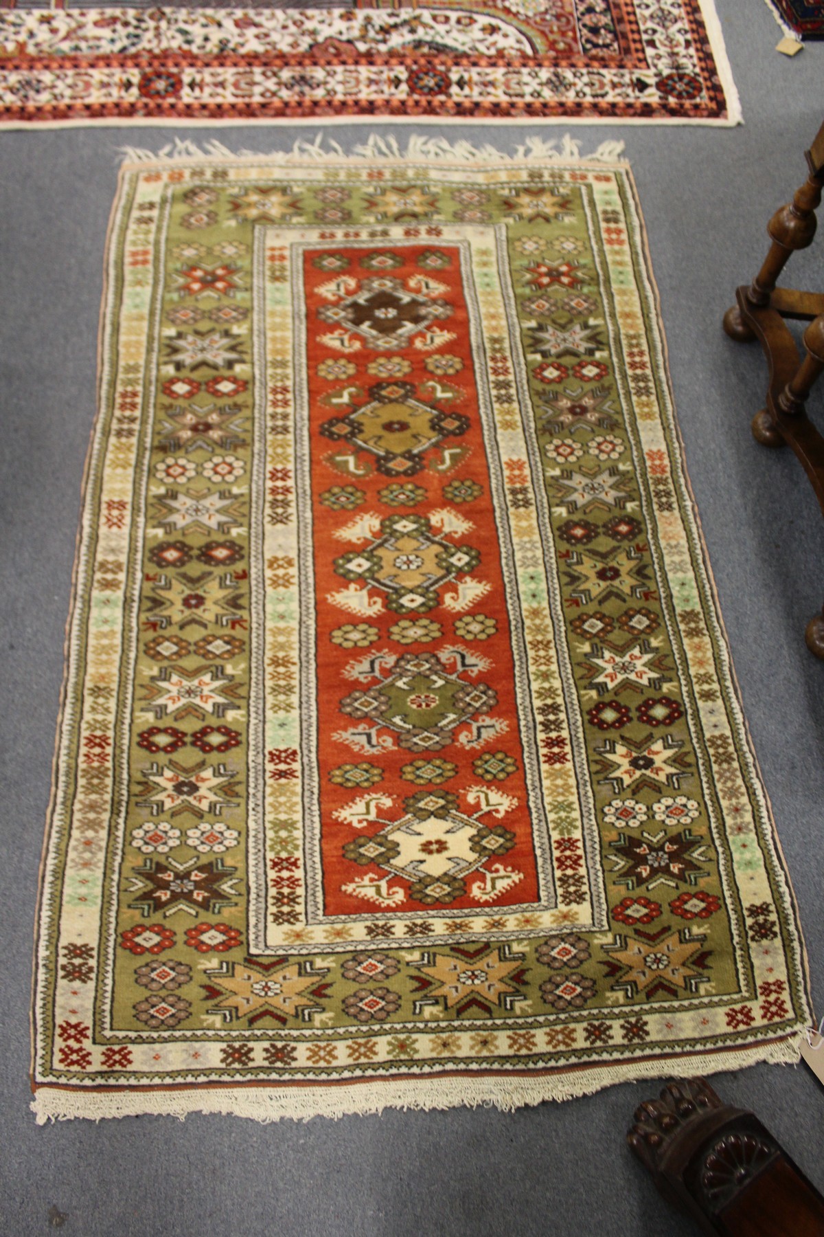 A modern Persian design rug, central red ground with stylized decoration within a similar green
