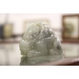 A Chinese carved celadon jade figure of a mythical beast or dragon.