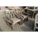 A pair of teak garden armchairs.