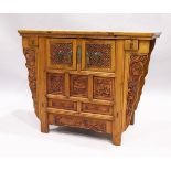 A CHINESE ALTAR TABLE with plain top carved front cupboard doors and drawers, 3 ft. 7 in. long, 1
