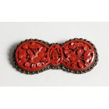 A CHINESE CINNABAR LACQUER BROOCH.