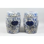 A PAIR OF CHINESE BLUE AND WHITE BARREL SEATS with scrolls, 17 ins high