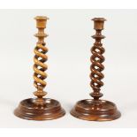 A PAIR OF TURNED SPIRAL OLIVE WOOD CANDLESTICKS 10 ins high