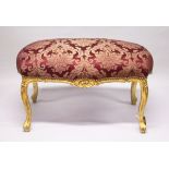 A GILT WOOD LARGE STOOL, with upholstered crimson, classical style fabric, on cabriole legs. 3 ft