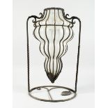 A FOUR TIER TINTED SHAPED GLASS VASE on a wrought iron stand, 13 ins diameter.