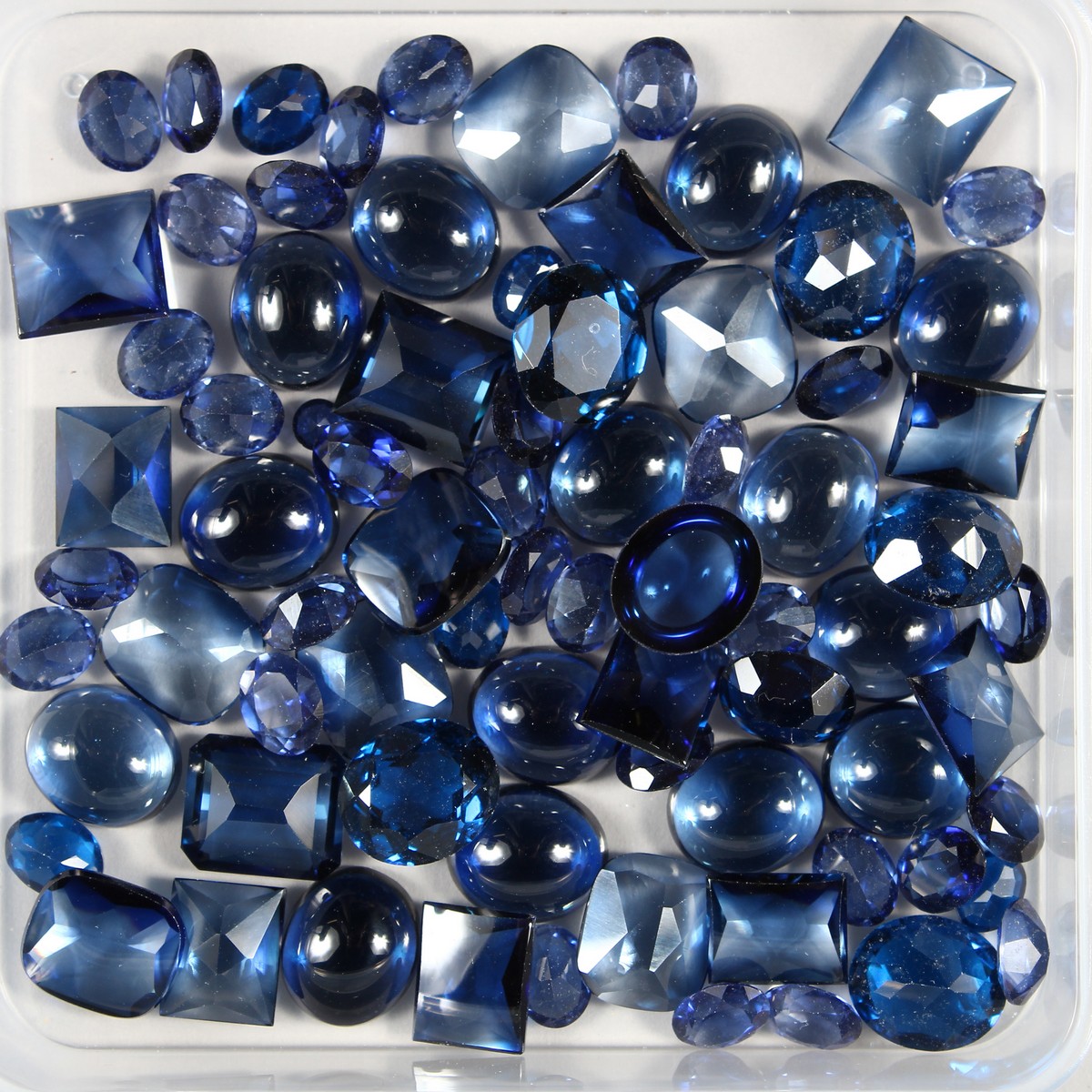 A BOX OF SAPPHIRE BUFF STONES