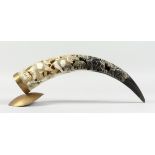 A BOVINE HORN carved with elephants, 18 in. long.