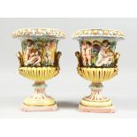 A PAIR OF CAPODIMONTE STYLE POTTERY URNS AND COVERS with panels of cupids. 9 ins. high.