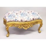 A GILT WOOD LARGE STOOL, upholstered with a floral print fabric on cabriole legs 3 ft 10 ins long