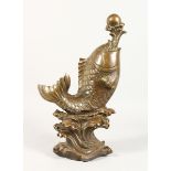 A CHINESE BRONZE CARP on a scrolling base. 7 ins high.