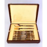 A GOOD BOXED CARVED RHINO HORN HANDLED CUTLERY 29 PIECE SERVICE, in line sectioned box. Circa 1920.