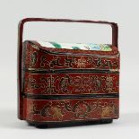 A CHINESE LACQUERED THREE TIERED BASKET.