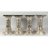 A SET OF FOUR SILVERED SQUARED TOP STANDS on octagonal bases, 15.5 in. high.