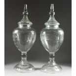 A LARGE PAIR OF CUT GLASS URN, SHAPED VASES AND COVERS, 31 ins. high.