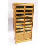A GOOD HABERDASHERY CABINET with eight pairs of sliding glass drawers with brass handles. The base